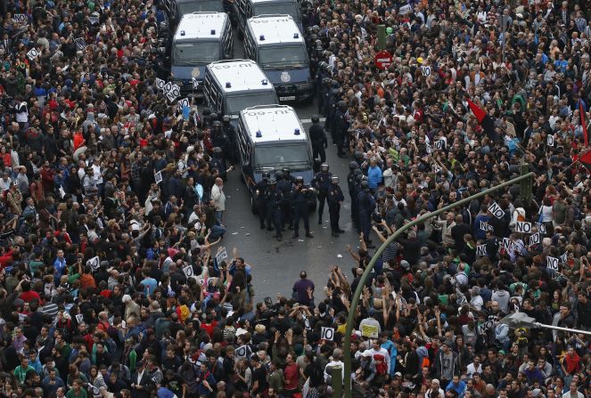 Protesters surround police vans near the Spanish Parliament in Madrid on Tuesday, September 25. Spain's unemployment is near 25%, and demonstrators -- fed up with anti-austerity measures -- accuse the government and opposition alike of trying to solve the country's financial woes on the backs of the people.