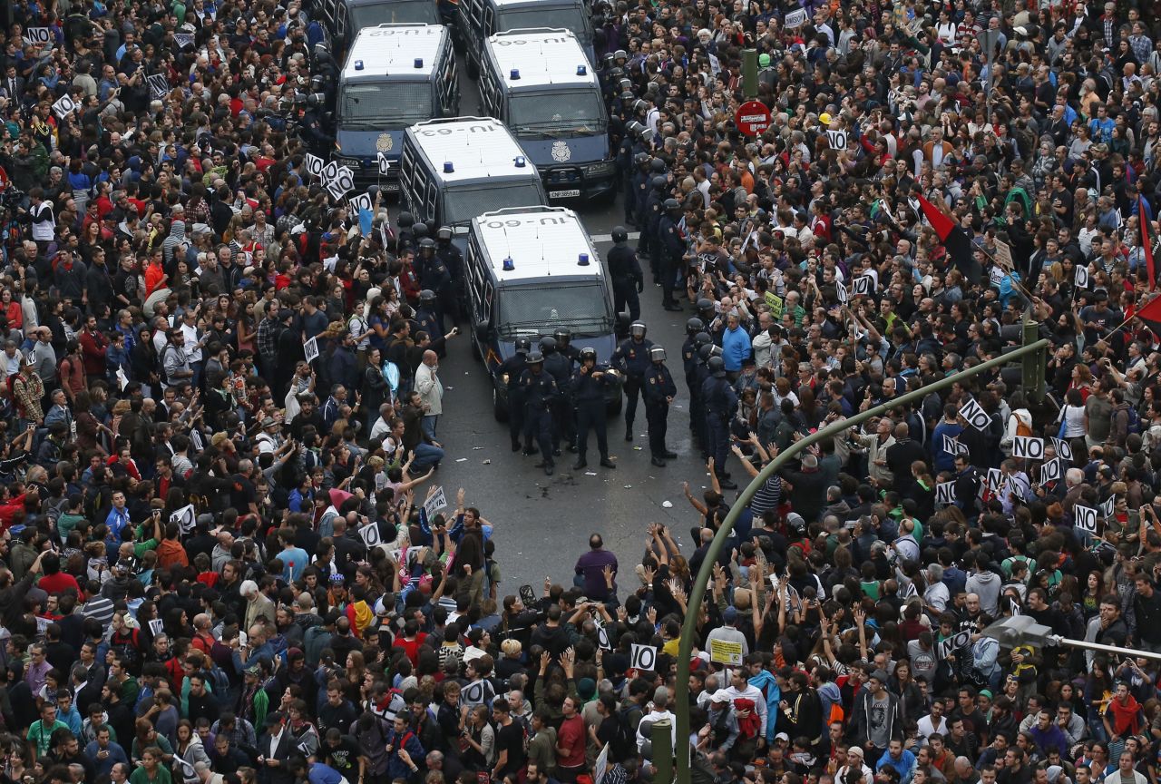Protesters surround police vans near the Spanish Parliament in Madrid on Tuesday, September 25. Spain's unemployment is near 25%, and demonstrators -- fed up with anti-austerity measures -- accuse the government and opposition alike of trying to solve the country's financial woes on the backs of the people.