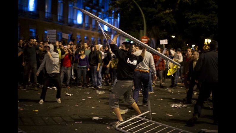 A demonstrator throws a fence toward riot police. Some protesters threw bottles and rocks at officers, who fought back, a state-run broadcaster reported.