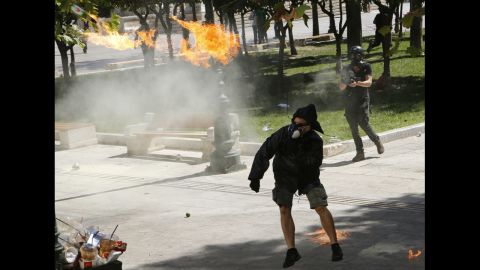 A demonstrator throws a Molotov cocktail at riot police near Syntagma Square on Wednesday.