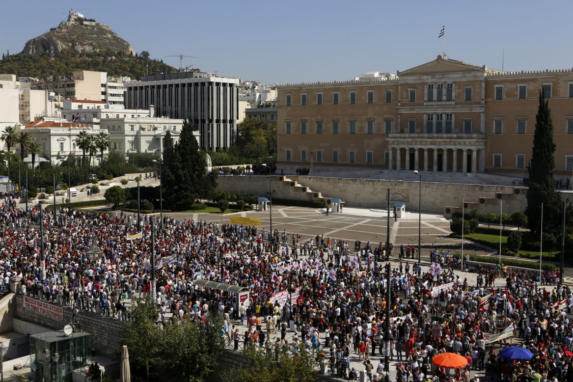 Demonstrators march by the parliament during the strike on Wednesday.