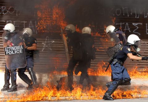 Riot police are surrounded by flames during violent clashes in Athens on Wednesday.