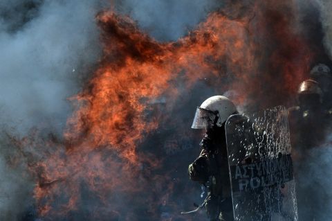 A fire bomb explodes near a riot police squad on Wednesday.