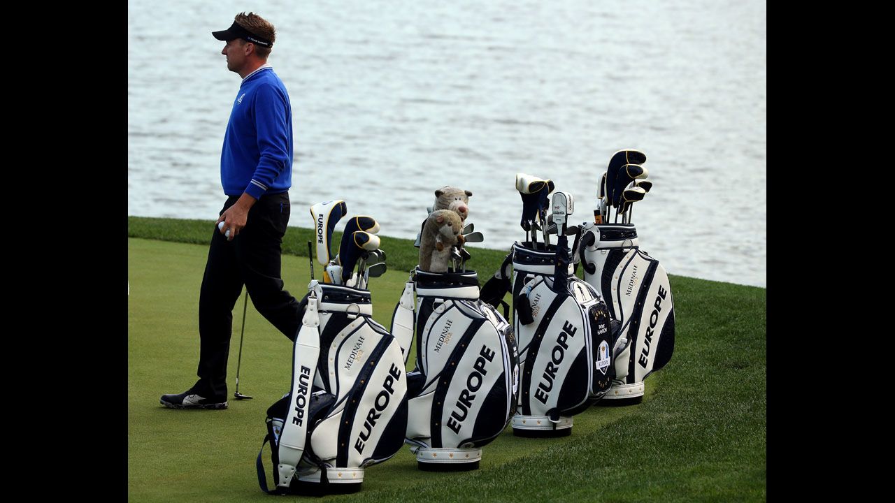 Ian Poulter of Europe practices near his teammates' golf bags Wednesday.
