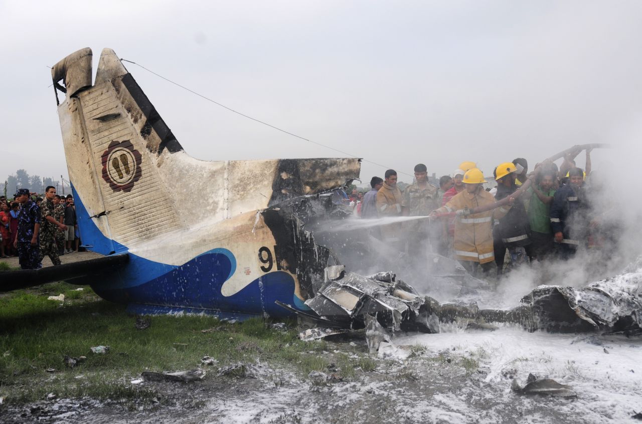 Nepalese firefighters and volunteers help put out flames from the wreckage of a crashed Sita Air plane outside Kathmandu, Nepal, on Friday, September 28. The Dornier-built aircraft went down minutes after takeoff from Kathmandu's international airport, reports said. All 19 aboard the plane died, Nepalese authorities said.