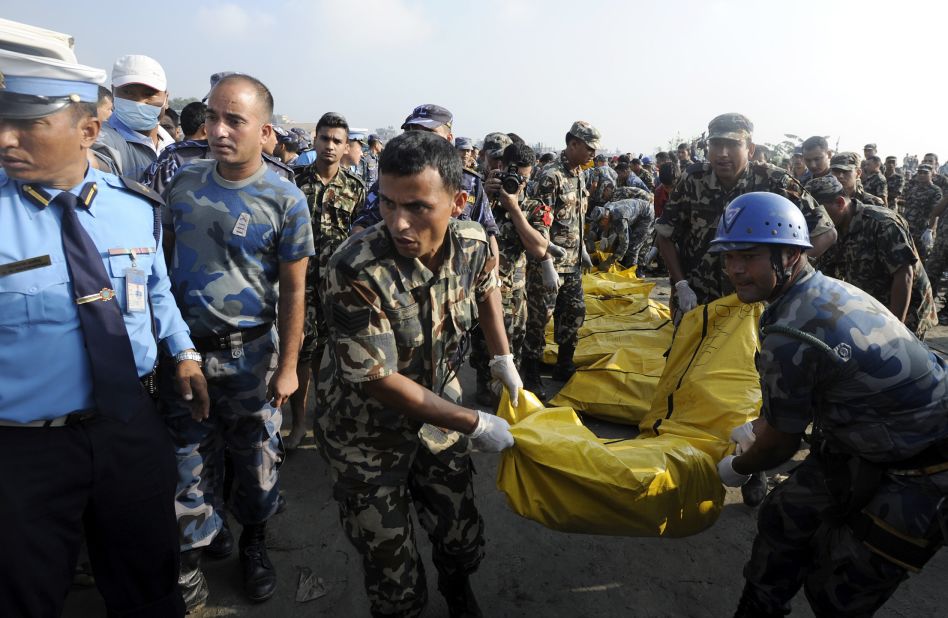 Members of a Nepalese rescue team remove bodies found in the wreckage. The UK Foreign Office confirmed that seven Britons were on the flight, and China's Ministry of Foreign Affairs also said five Chinese died.