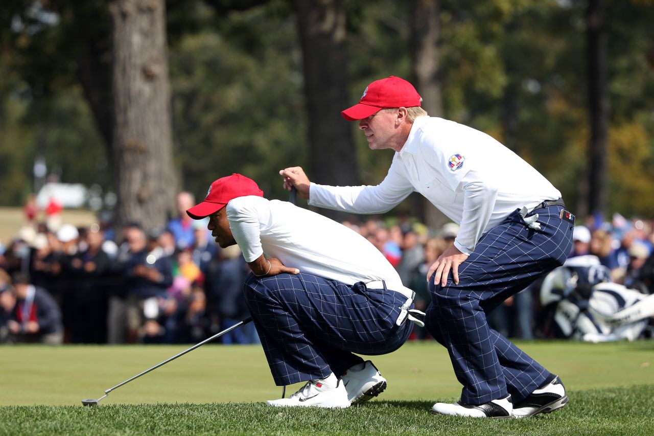 Tiger Woods and Steve Stricker line up a putt during the morning foursome matches on Friday.