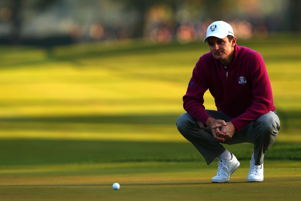 Golfer Justin Rose of Europe lines up a putt on the first green.