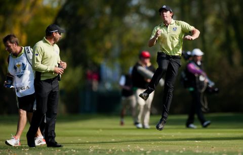 Rory McIlroy of Northern Ireland, right, jumps in the air while speaking with teammate Sergio Garcia of Spain, ssecond left, on the 10th fairway on Friday.