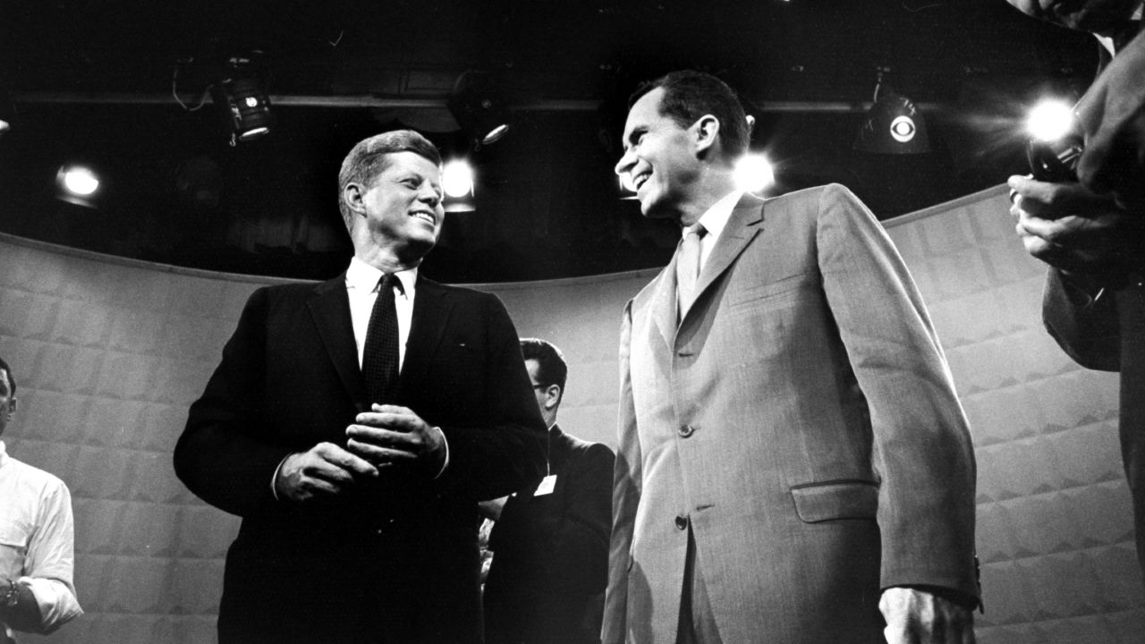 John F. Kennedy and Richard Nixon exchange smiles beneath glaring lights before their first TV debate in 1960. 
