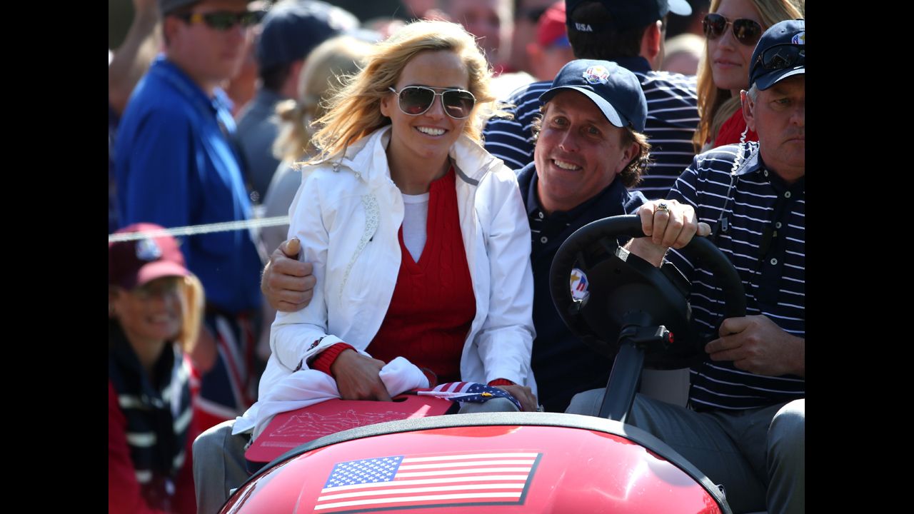 Phil Mickelson of the United States drives with his wife Amy Mickelson on the 16th green.