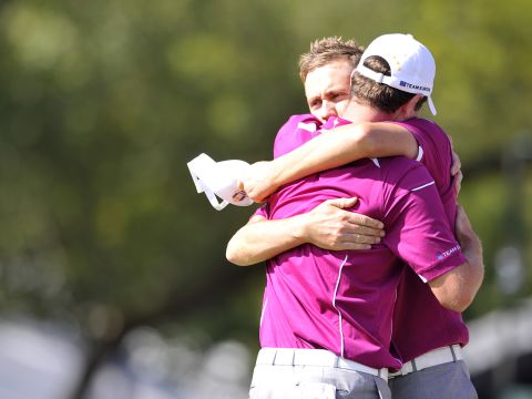 Poulter and Justin Rose of Team Europe embrace after winning their match on Saturday.