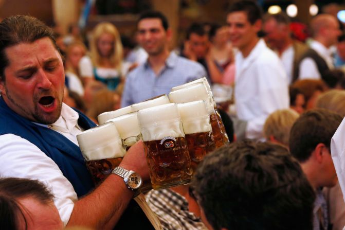 A waiter carries beer mugs through the Braeurosl beer tent during day seven of Oktoberfest 2012 on Friday, September 28, in Munich. 