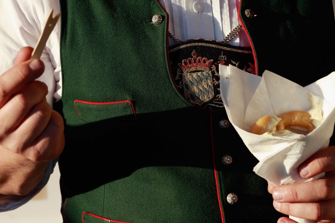 A man dressed in traditional Bavarian clothing eats fried calamari on Friday. 