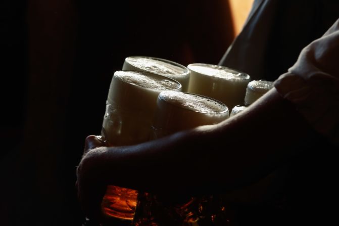 A waitress carries mugs of beer to customers at the Braeurosl beer tent.