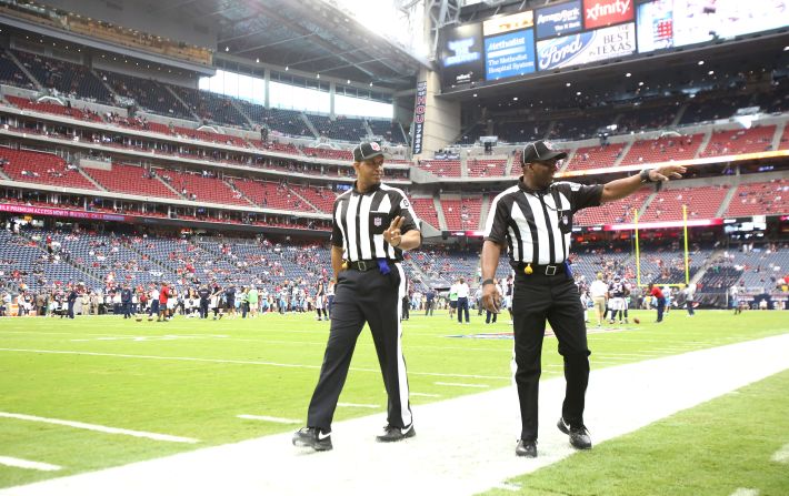 NFL officials wave to the fans during the pre-game warmup on Sunday at the Tennessee Titans-Houston Texans game.