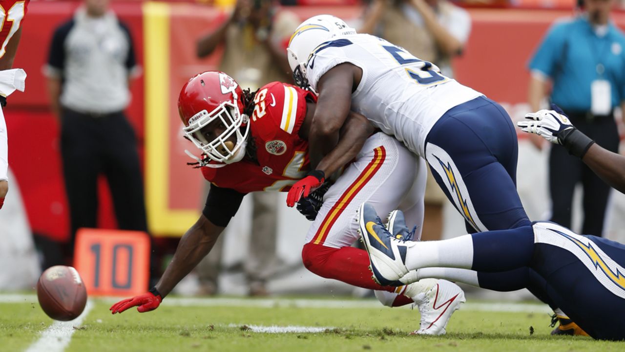 Takeo Spikes of the San Diego Chargers forces a fumble by Jamaal Charles of the Kansas City Chiefs on Sunday.