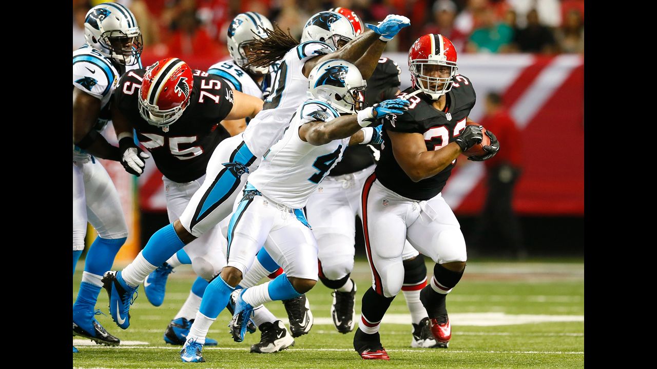 Michael Turner of the Atlanta Falcons rushes away from Carolina Panthers defenders on Sunday.