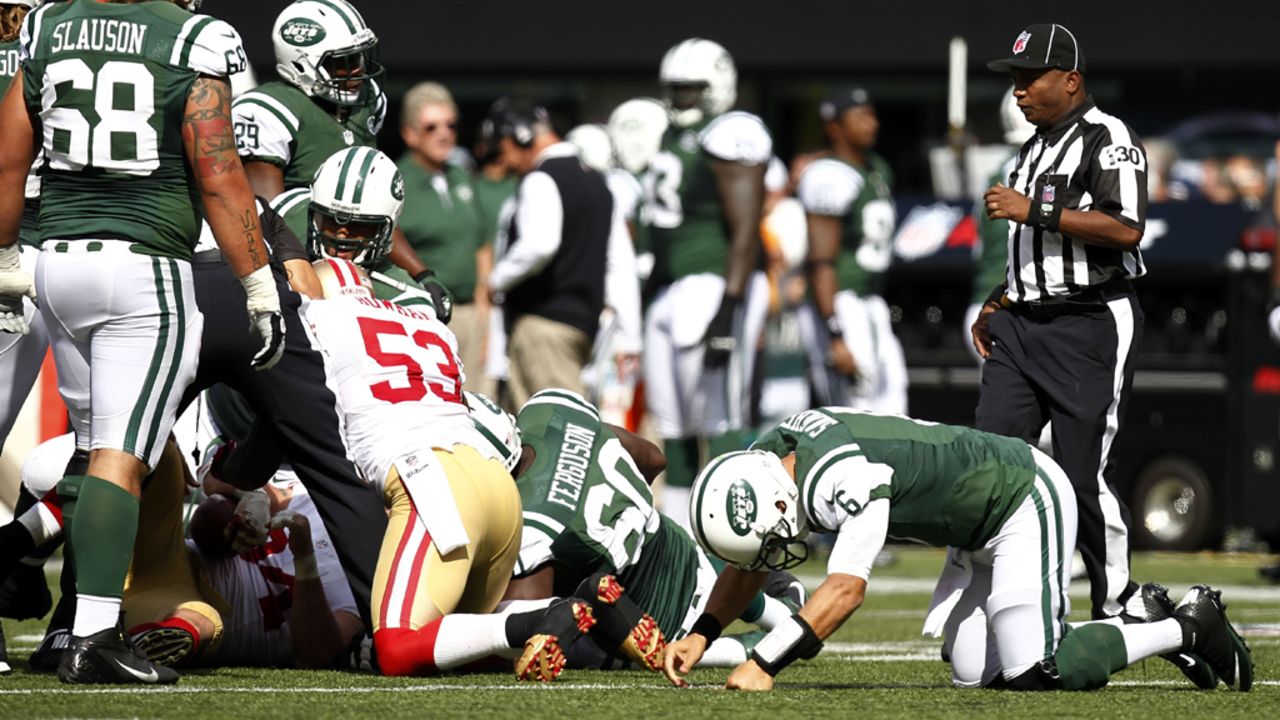Quaterback Mark Sanchez of the New York Jets, right, gets back to his feet after a fumble against the San Francisco 49ers on Sunday at MetLife Stadium in East Rutherford, New Jersey.