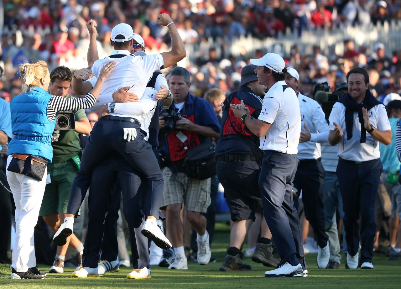 Martin Kaymer is mobbed by the European team after he made the winning putt on the 18th green on Sunday to cinch the Ryder Cup.