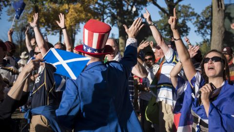 A U.S. fan high-fives Team Europe's fans after their Ryder Cup victory on Sunday.