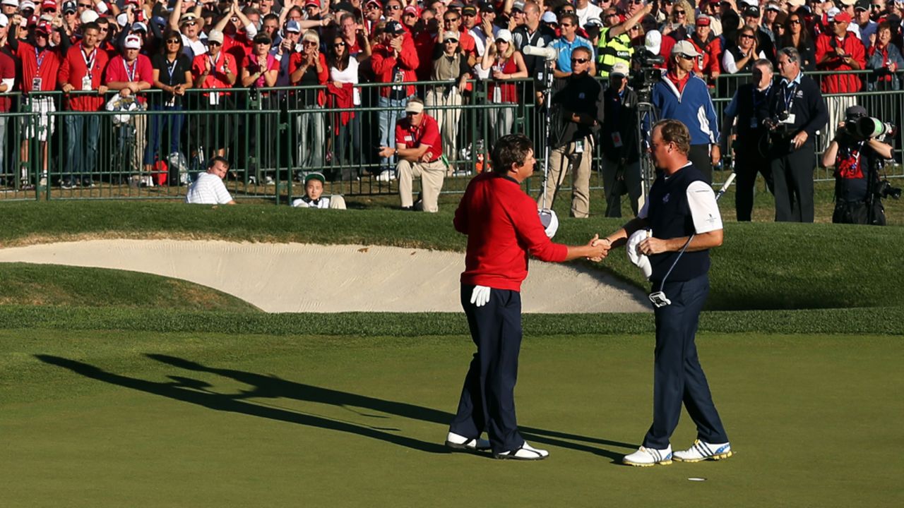 Jason Dufner of the United States, left, shakes hands with Peter Hanson on the 18th green after Dufner defeated Hanson.