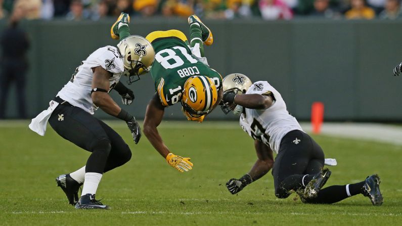 Randall Cobb of the Green Bay Packers flips in the air Sunday after being hit by Corey White, left, and Malcolm Jenkins of the New Orleans Saints.