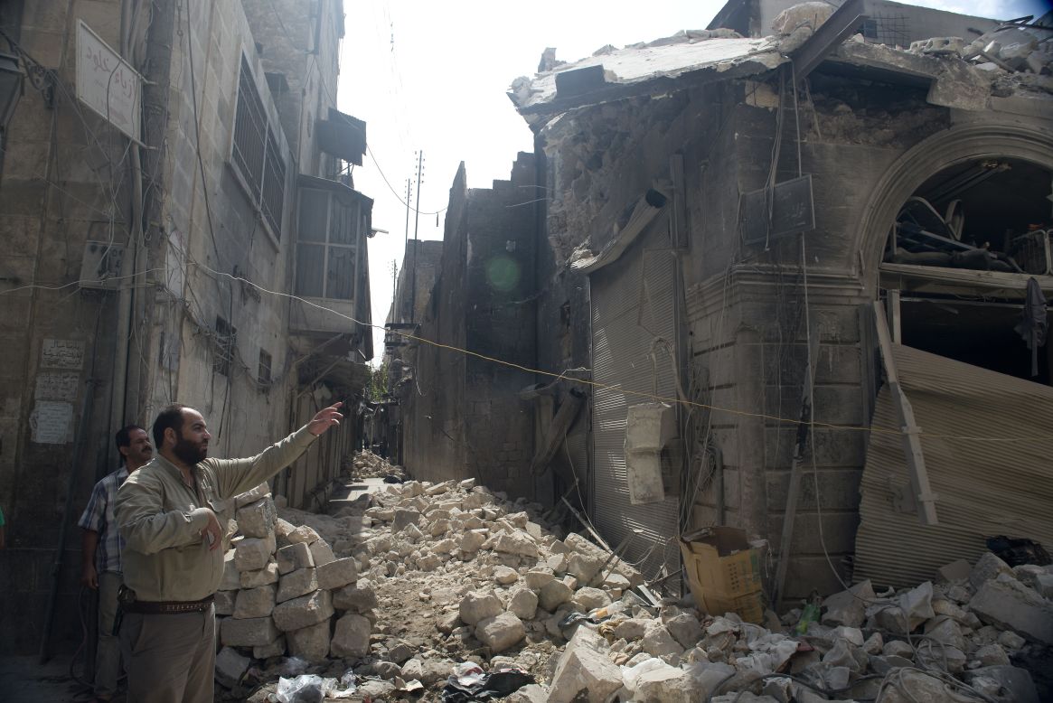 Syrians inspect damages in the old city of Aleppo after the area was shelled by Syrian regime forces on Sunday.