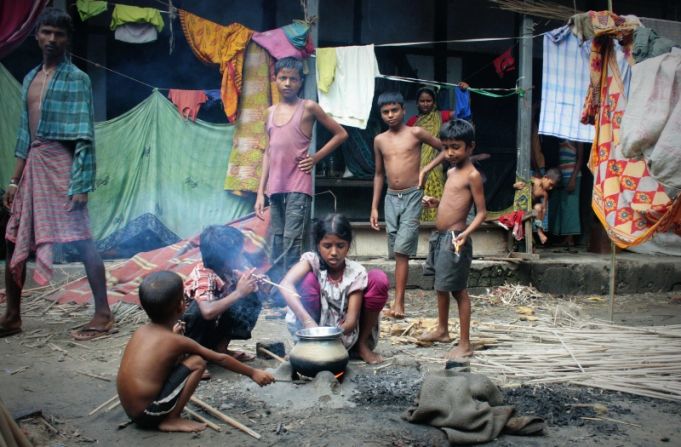 Children who live in a relief camp in a school in Chirang district cook food in the courtyard. 