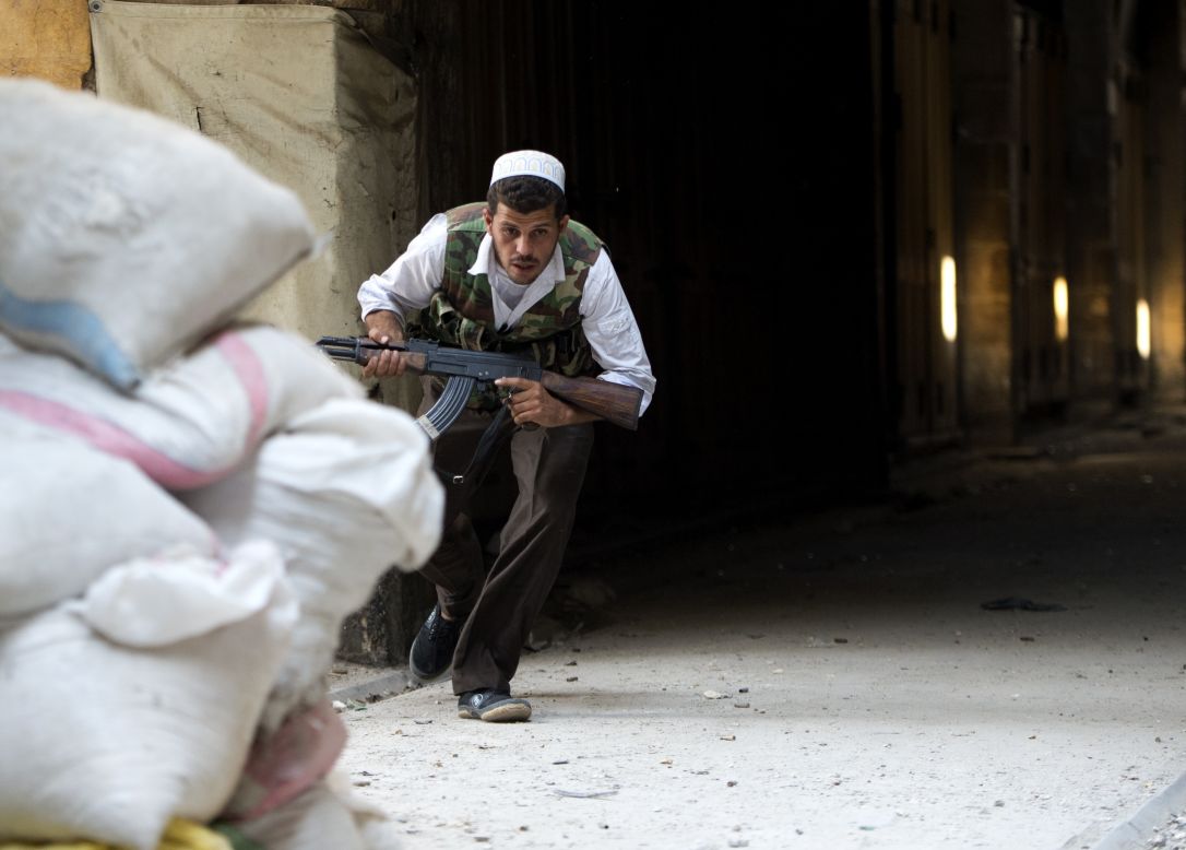 A Syrian rebel ducks for cover during clashes to control the area around the Zacharias mosque in the old city of Aleppo.
