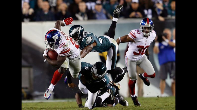 David Wilson of the Giants is tackled by Brandon Boykin, top, center, and Alex Henery of the Eagles on a kick return Sunday.