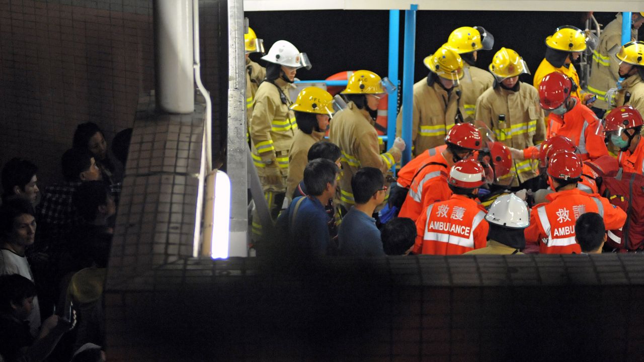 Local residents try to get a glimpse of rescue personnel as they tend to a victim Monday night. The incident happened around 8:20 p.m. local time, just off the coast of Lamma Island, southwest of Hong Kong.