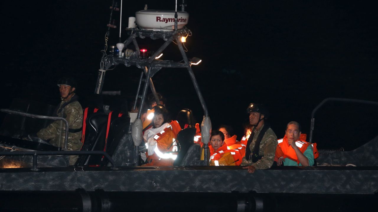 Survivors are transported to shore on a police boat late Monday.
