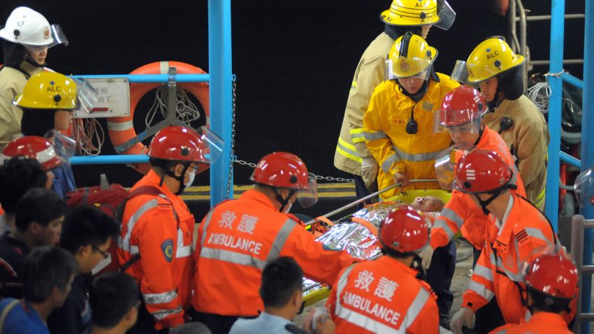A victim (C) is carried ashore by rescue personnel after at least 20 people were injured in a collision between a ferry and another commercial vessel off Hong Kong on October 1, 2012. Search and rescue operations were under way for around 80 other people who were involved in the accident near Lamma Island, a police spokesman said.      AFP PHOTO / RICHARD A. BROOKS        (Photo credit should read RICHARD A. BROOKS/AFP/GettyImages)