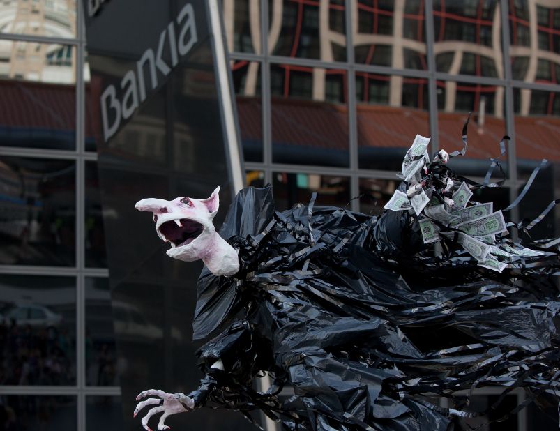 A vampire puppet holding money is held by protesters outside Bankia's building Kio Tower in Plaza Castilla, on June 2, 2012 in Madrid