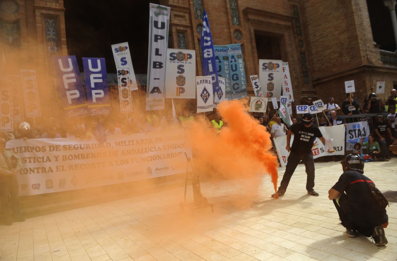Protesters walk through smoke thrown by firemen and policemen during a demonstration of public service workers in Spanish Sevilla on September 29, 2012.