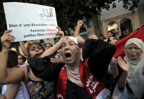 Tunisian women protest Tuesday, October 2, in front of a courthouse in Tunis where a young woman faces charges of indecency by two police officers accused of raping her. 