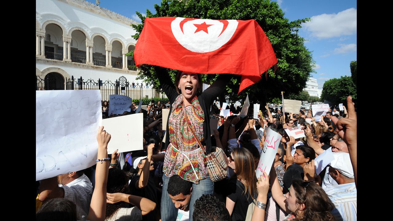 A Tunisian protester holds up a national flag.