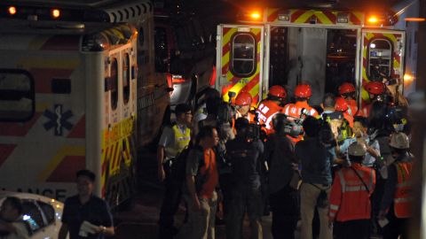 Members of the media surround rescue workers as they carry a victim into an ambulance Monday night.
