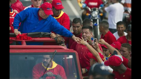 Chavez greets supporters during a campaign rally in Sabaneta on Monday. He dismissed his much younger challenger as a "fly" not worth chasing when challenged to a debate this year.