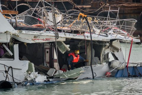A fireman inspects the back end of the badly damaged Lamma IV passenger boat two days after the collision.