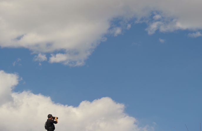 A member of the U.S. Secret Service keeps watch from the top of a building as Obama takes part in a debate walk-through at the University of Denver on Wednesday.