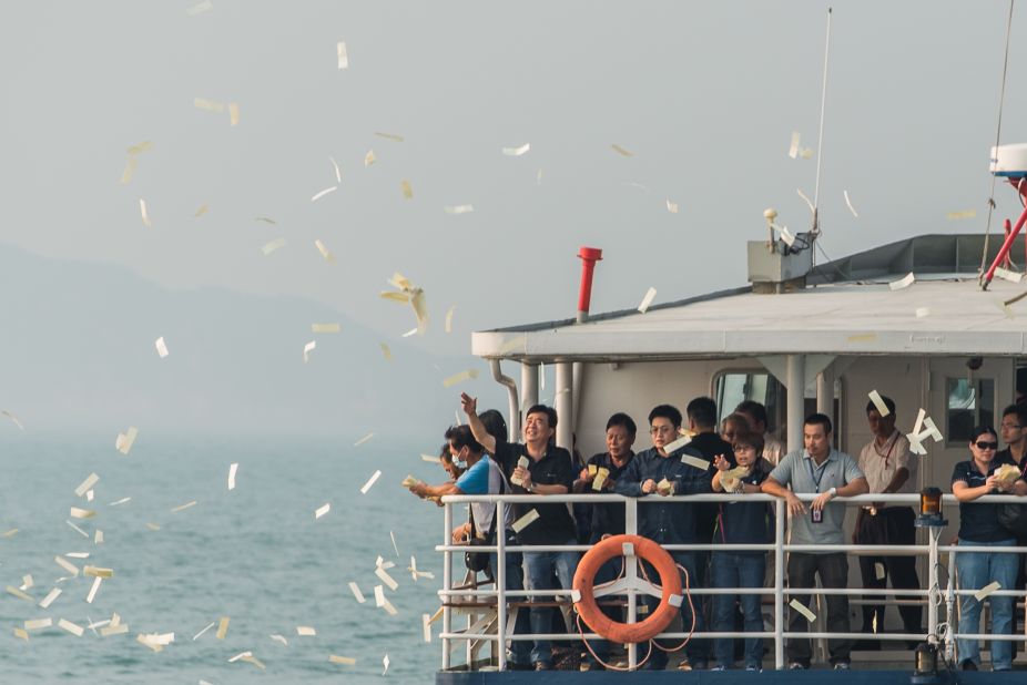 Mourners throw paper offerings into the sea Thursday during a ceremony held for the victims of the ferry collision.