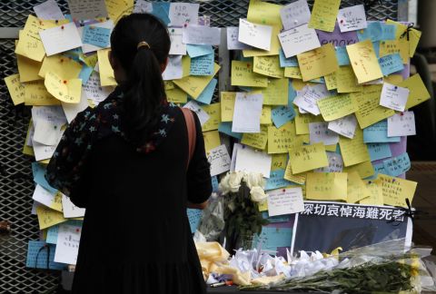 A girl stands in front of a memorial at a ferry pier on Thursday. Hong Kong held a three-day, city-wide mourning period honoring those who died in Monday's ferry collision.