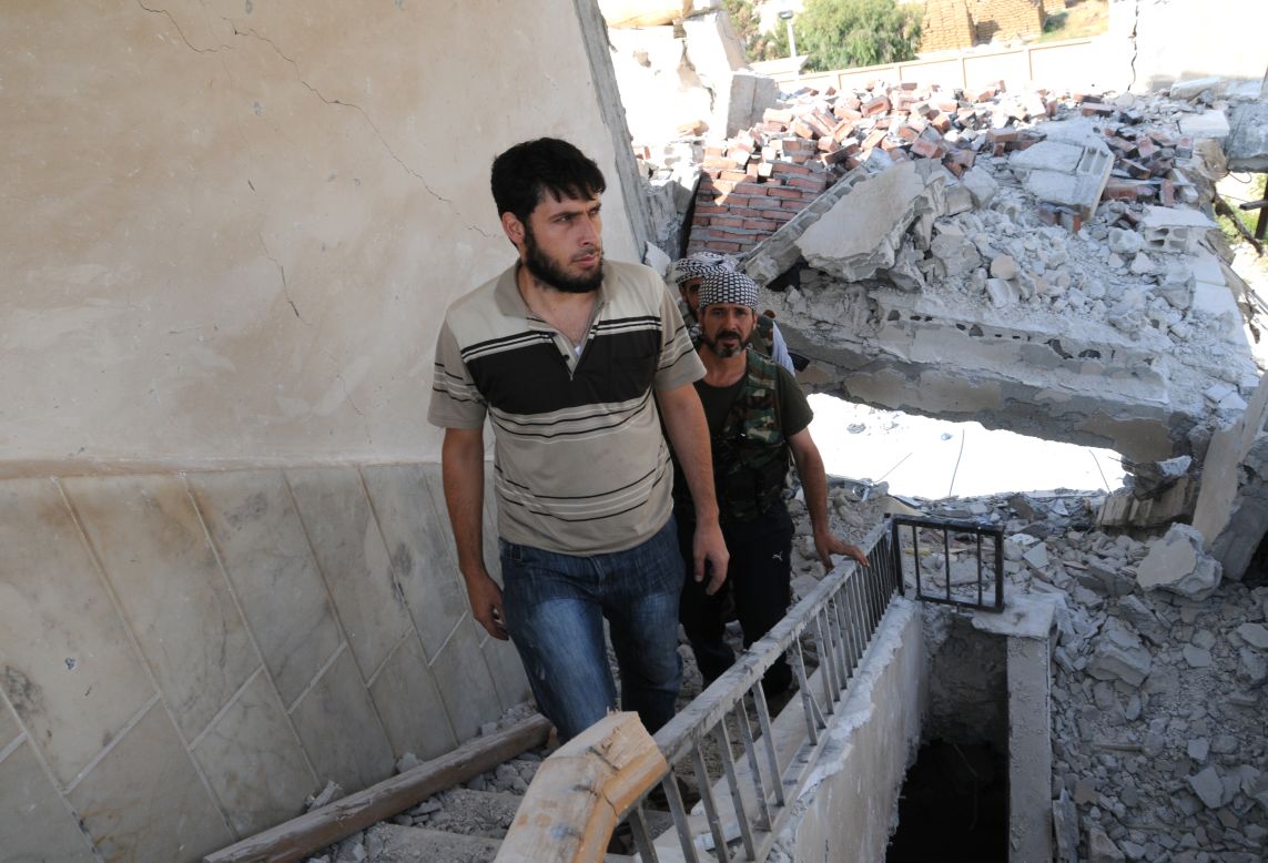 Rebels climb the stairs of a destroyed building Thursday in Tal Abyadh.