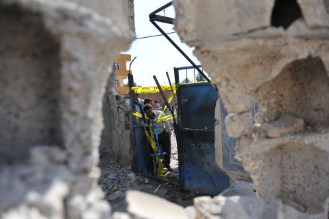 Residents check on a damaged house Thursday, where five Turkish civilians were killed by a mortar in the southern border town of Akcakale on Wednesday, October 3.