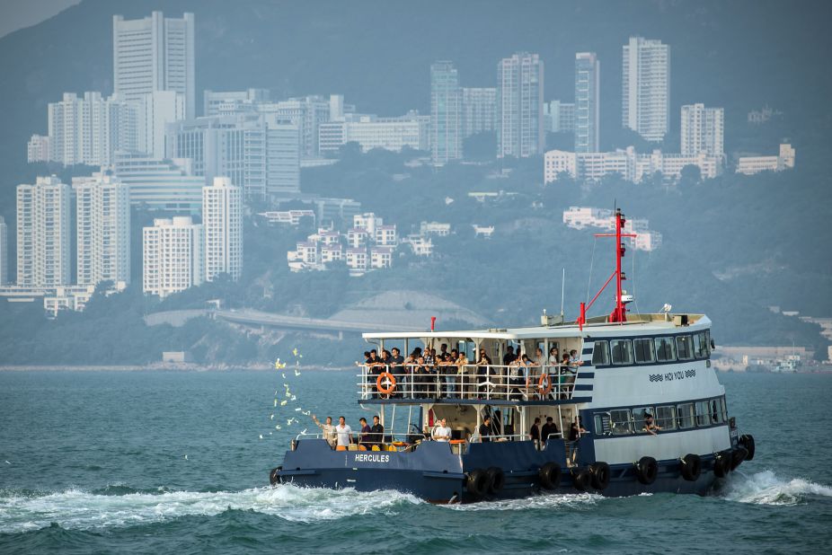 Mourners accompanied by Taoist priests take boats on Thursday, October 4, to go to the scene of the boat collision that killed 38 people off Lamma Island, near Hong Kong, on October 1. They throw paper offerings for the dead into the sea. 