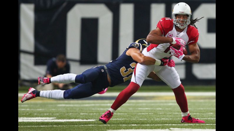 Larry Fitzgerald of the Arizona Cardinals attempts to break a tackle by Cortland Finneganof the St. Louis Rams.