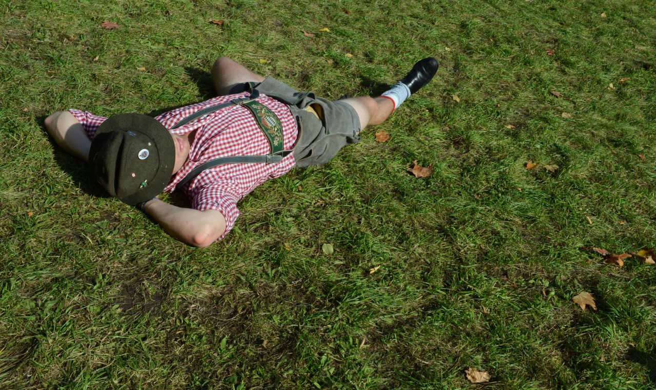 An Oktoberfest visitor has a rest on the lawn at the Theresienwiese.