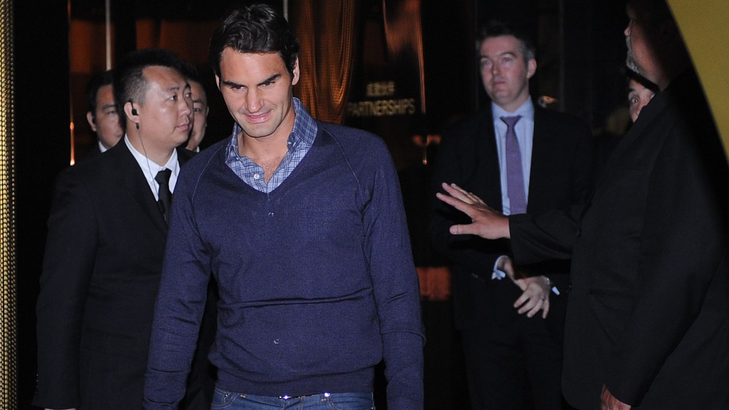 Roger Federer is flanked by security guard as he arrives for the ceremonial draw for the Shanghai Masters in China.